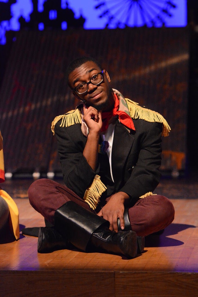 Malik seated in costume with gold-fringed epaulets