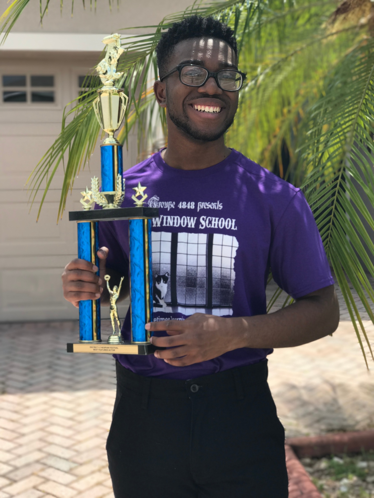 Malik holding a Best Featured Actor trophy