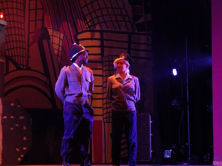 Malik on stage in Urinetown