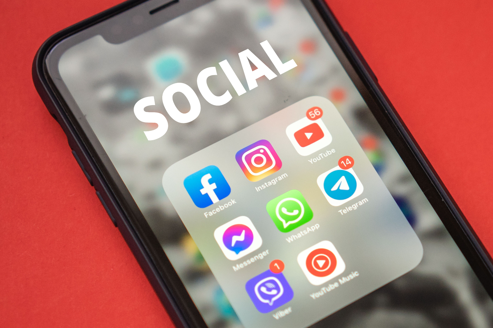 Smartphone displaying social media apps on a red background